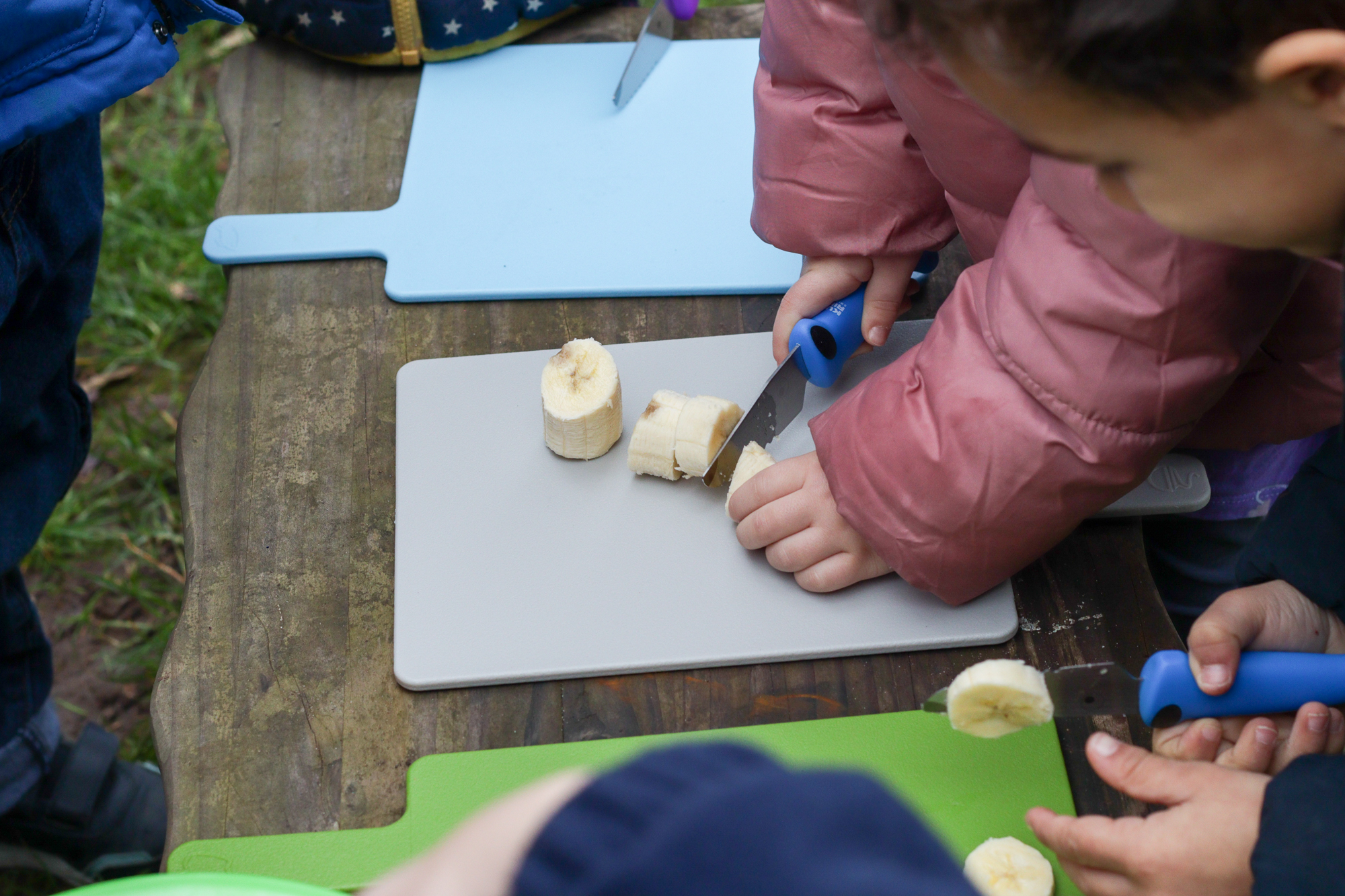 Child Cutting Banana for Snack