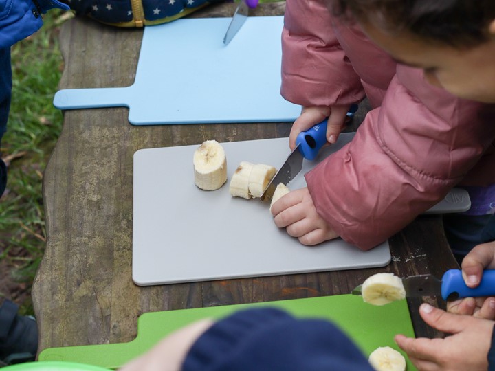 Child Cutting Banana for Snack