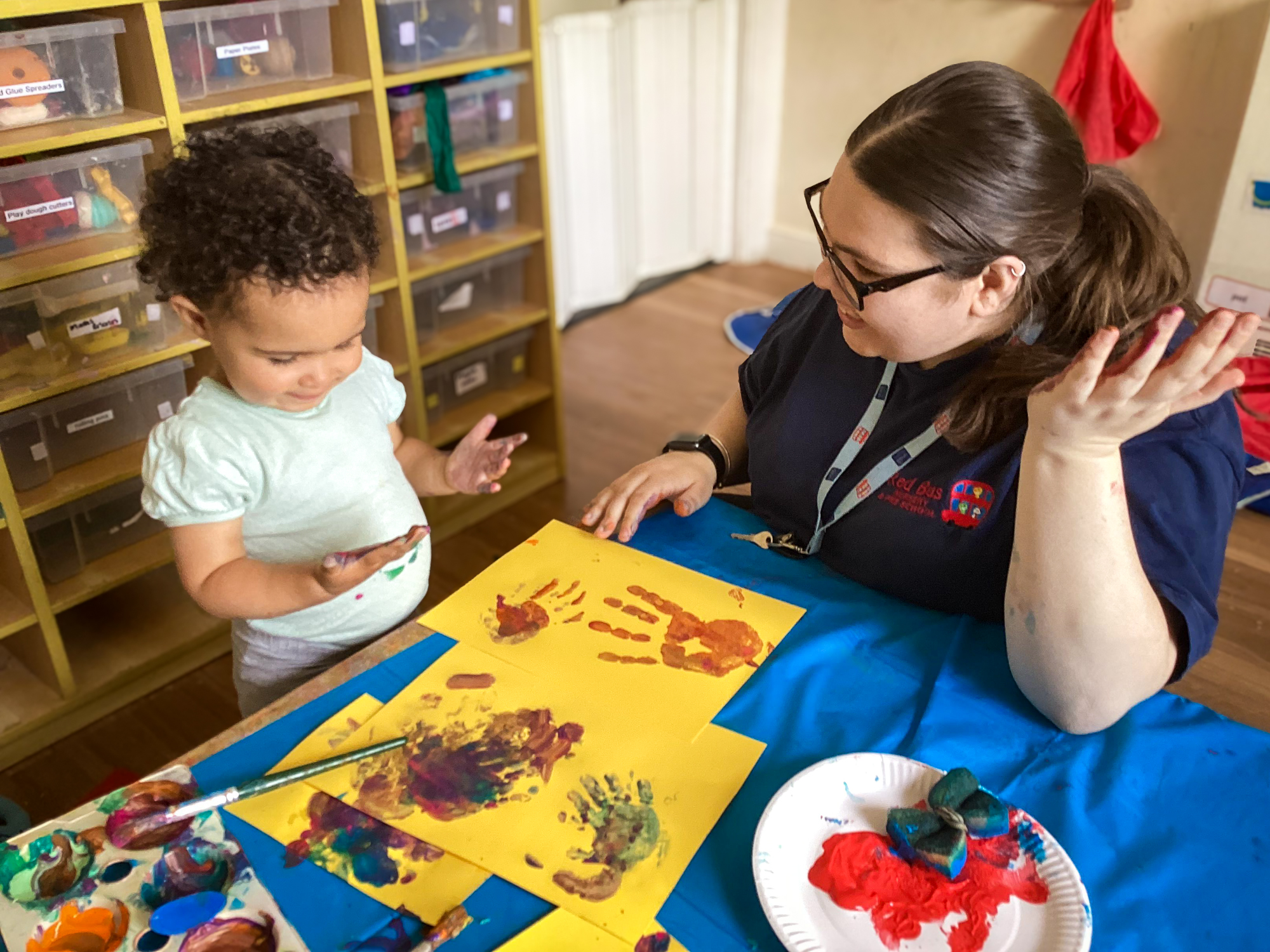 practitioner and baby creating hand prints in art studio